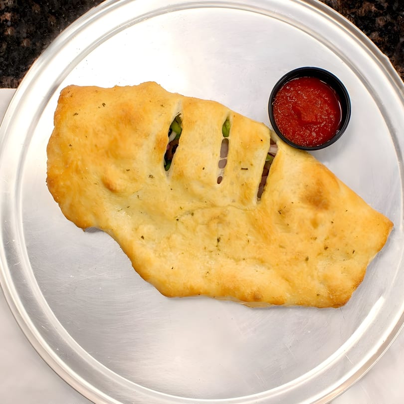 Golden-brown La Pizzeria stromboli with visible fillings and a side of red marinara sauce on a metal tray.