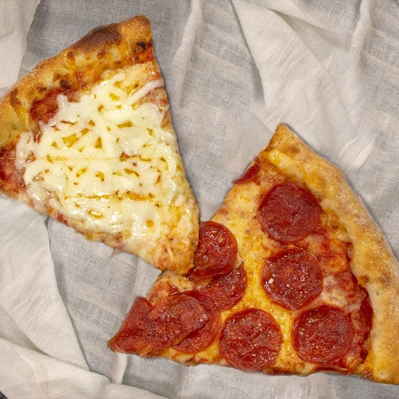 Two slices of La Pizzeria pizza, one cheese and one pepperoni, on a white cloth.